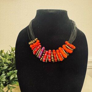 Multi-strand statement necklace with rolled fabric beads and metallic spacers